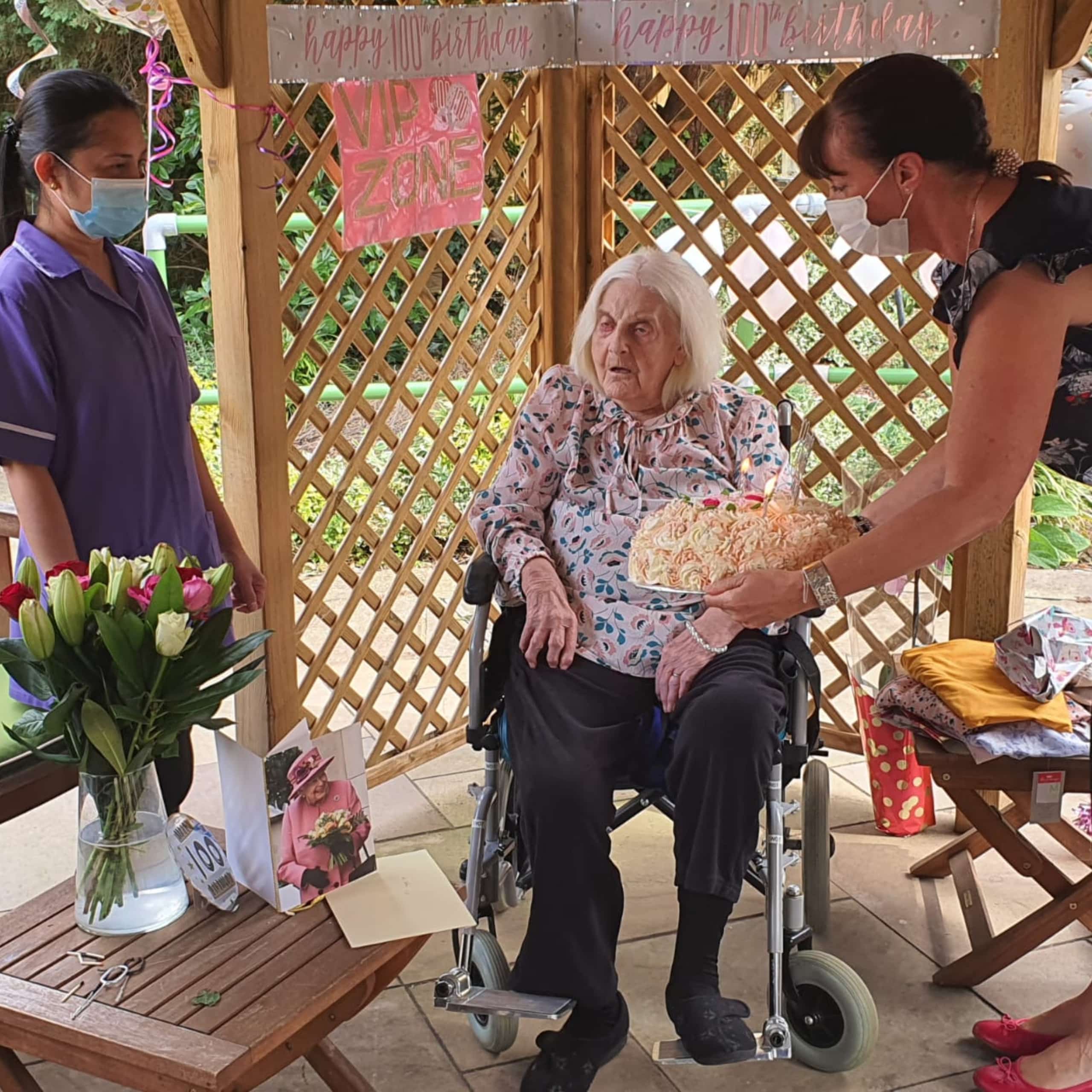 Linden House Care Home manager, Paula Windmill and a carer presenting Hilda with her 100th birthday cake.