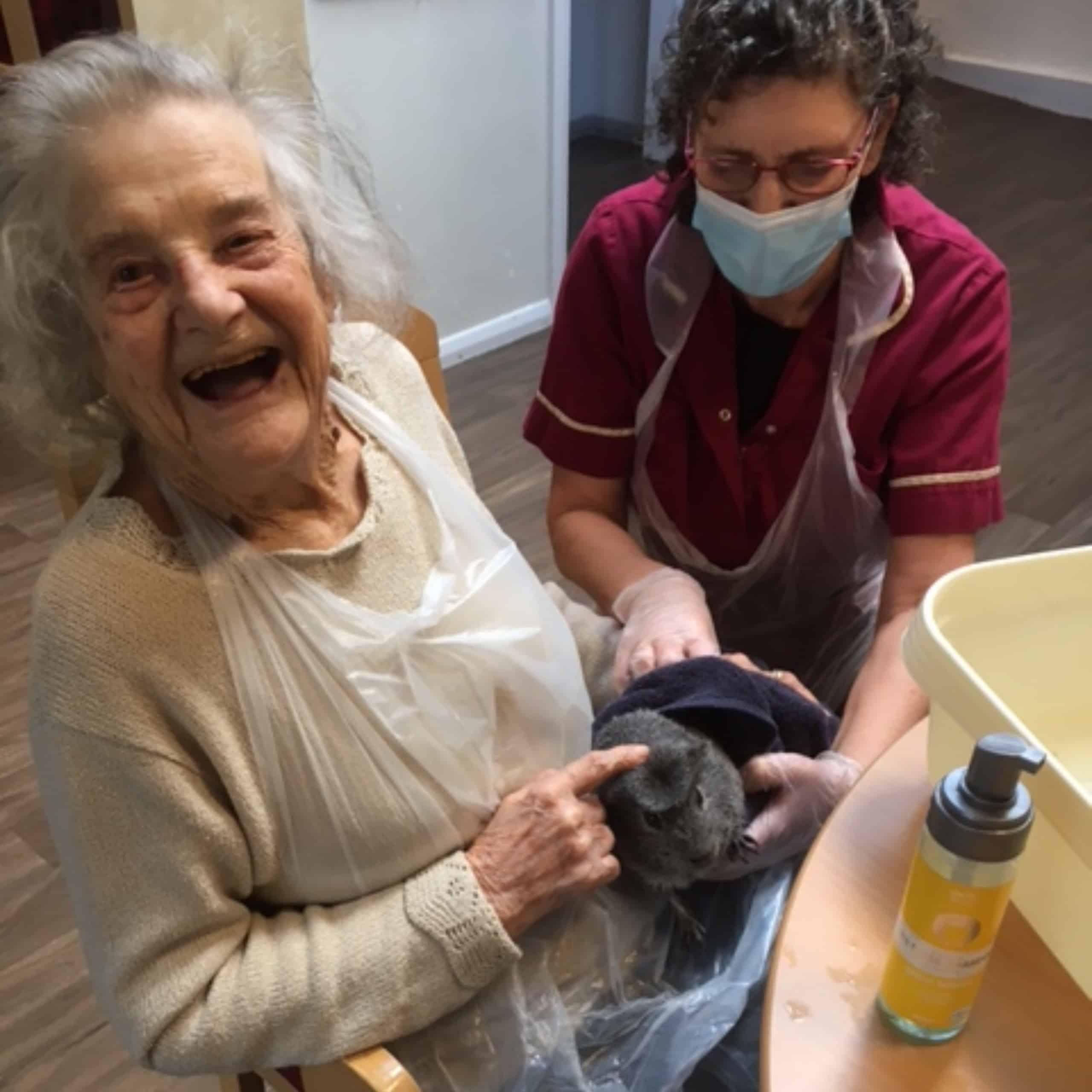Linden House resident Joan enjoying spending time with one of the Epsom care home's pet guinea pigs.