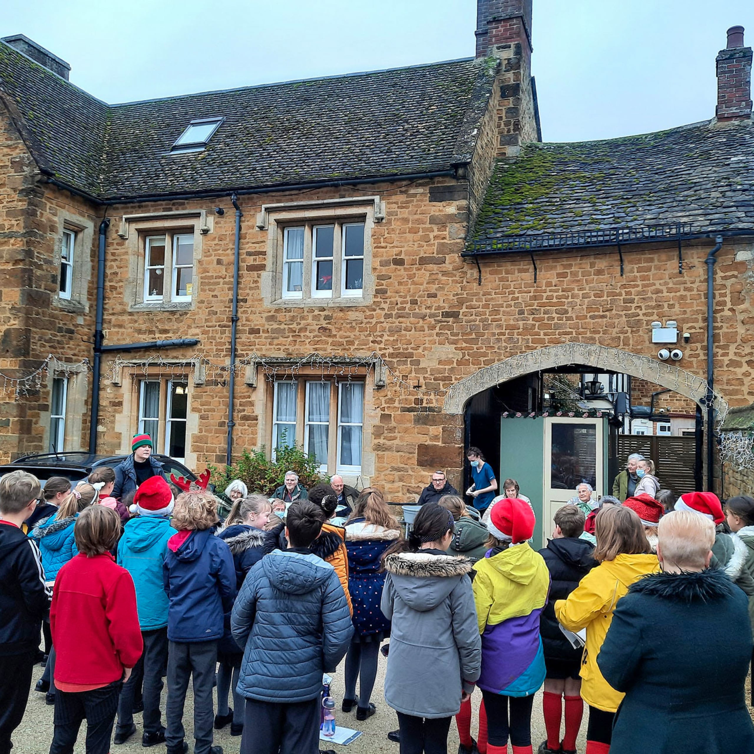 Residents and team members from Featherton House Care Home in Deddington watch children from Deddington Church of England Primary School sing Christmas carols outside the home.